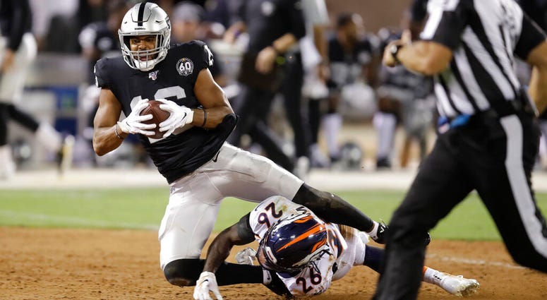 In this Sept. 9, 2019, file photo, Oakland Raiders wide receiver Tyrell Williams tumbles over Denver Broncos cornerback Isaac Yiadom (26) after making a reception during the first half of an NFL football game in Oakland, Calif. AP DO NOT USE