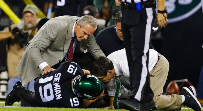 Trainers check on New York Jets quarterback Trevor Siemian (19) after he was injured during the first half of an NFL football game against the Cleveland Browns, Monday, Sept. 16, 2019, in East Rutherford, N.J. AP DO NOT USE