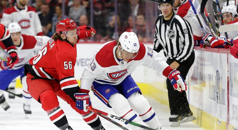 Carolina Hurricanes left wing Erik Haula (56), of Finland, reaches across Montreal Canadiens center Max Domi (13) during the first period of an NHL hockey game in Raleigh, N.C., Thursday, Oct. 3, 2019. AP DO NOT USE
