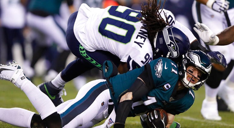 Seattle Seahawks' Jadeveon Clowney (90) hits Philadelphia Eagles' Carson Wentz (11) during the first half of an NFL wild-card playoff football game, Sunday, Jan. 5, 2020, in Philadelphia.
