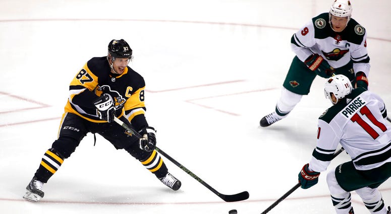 Pittsburgh Penguins' Sidney Crosby (87) gets off a pass with Minnesota Wild's Zach Parise (11) and Mikko Koivu (9) defending during the first period of an NHL hockey game in Pittsburgh, Tuesday, Jan. 14, 2020. AP DO NOT USE