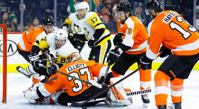 Pittsburgh Penguins' Sidney Crosby (87) tries to get a shot past Philadelphia Flyers' Brian Elliott (37) as Philippe Myers (5), Ivan Provorov (9) and Kevin Hayes (13) defend during the third period of an NHL hockey game, Tuesday, Jan. 21, 2020, in Philade AP DO NOT USE