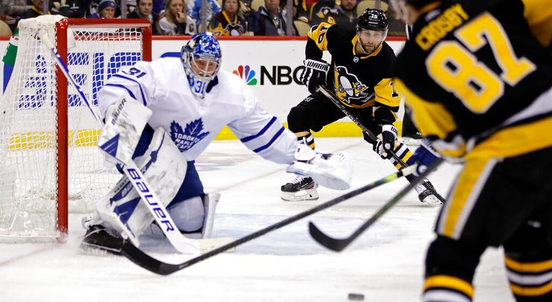 Pittsburgh Penguins' Sidney Crosby (87) passes to Jason Zucker (16) who put a shot behind Toronto Maple Leafs goaltender Frederik Andersen (31) for a goal during the second period of an NHL hockey game in Pittsburgh, Tuesday, Feb. 18, 2020.
