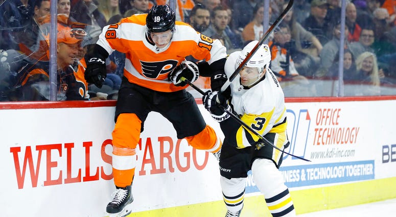 Philadelphia Flyers' Tyler Pitlick, left, tries to jump past Pittsburgh Penguins' Jack Johnson