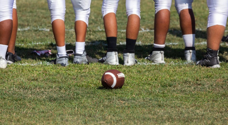 Football placed on field – Players getting ready for the game Football placed on field – Players getting ready for the game
