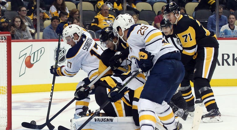 Pittsburgh Penguins defenseman Kris Letang (middle) clears the puck out of the crease behind goaltender Matt Murray (30) before Buffalo Sabres center Vladimir Sobotka (17) can score