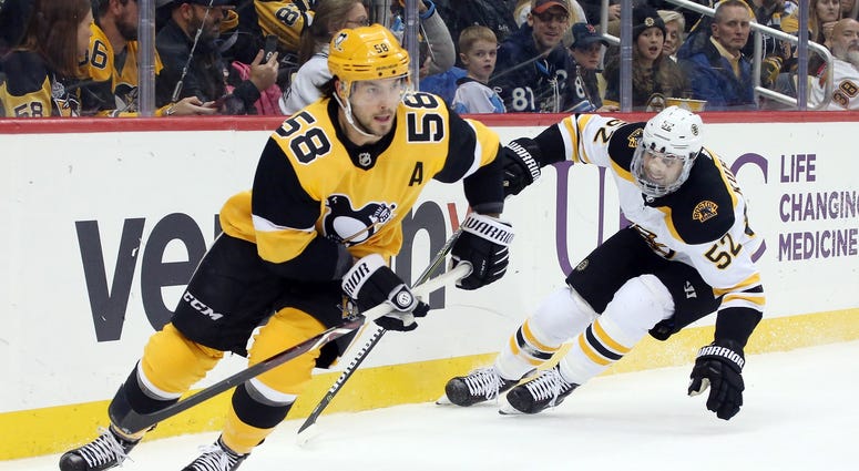 defenseman Kris Letang (58) moves the puck ahead Boston Bruins center Sean Kuraly