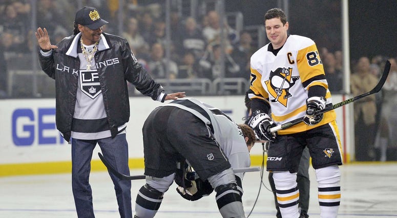 Hip-Hop artist Snoop Dogg reacts after dropping the puck before the game in front of Pittsburgh Penguins center Crosby