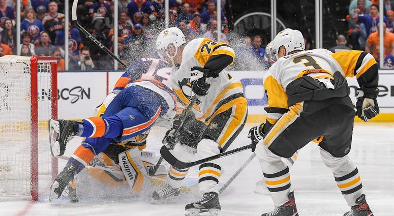 New York Islanders right wing Tom Kuhnhackl (14) falls into Pittsburgh Penguins goaltender Matt Murray