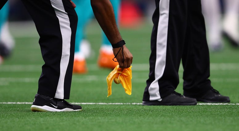 NFL Official picking up a penalty flag