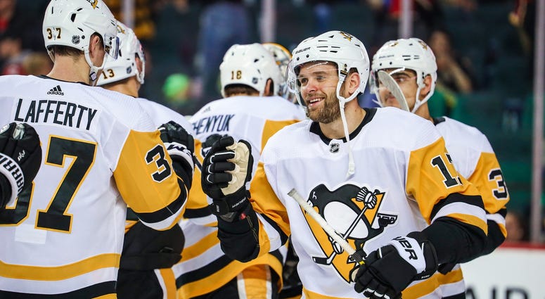 Bryan Rust (17) celebrates their win with teammates against the Calgary Flames Bryan Rust (17) celebrates their win with teammates against the Calgary Flames