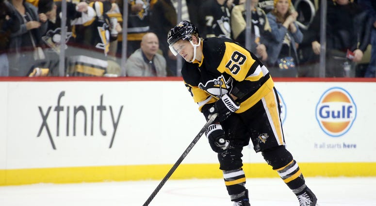 Jake Guentzel (59) leaves the ice after suffering an apparent injury