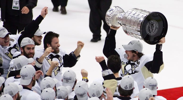Pittsburgh Penguins center Sidney Crosby (top right) celebrates with teammates after receiving the Stanley Cup following game seven of the 2009 Stanley Cup finals against the Detroit Red Wings a