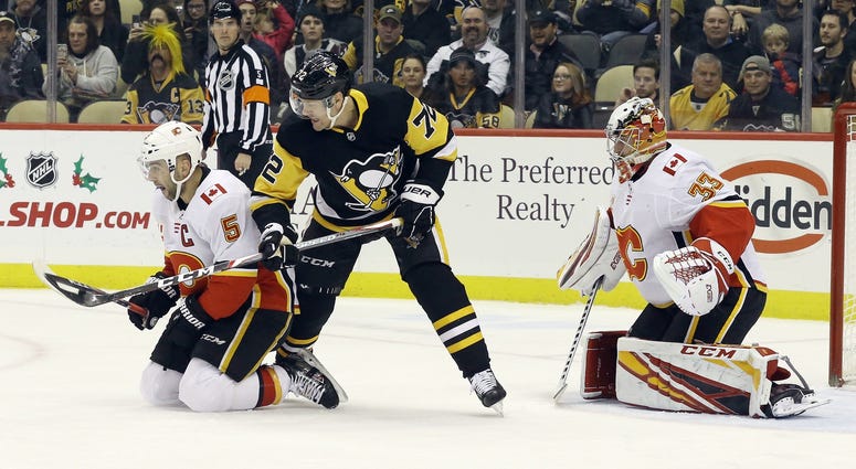 Calgary Flames defenseman Mark Giordano (5) and Pittsburgh Penguins right wing Patric Hornqvist (72) battle for the puck in front of Flames goaltender David Rittich (33) during the first period at PPG Paints Arena