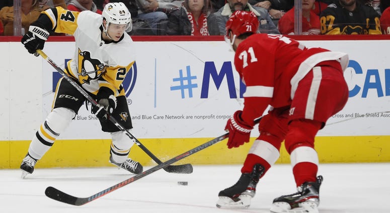 Pittsburgh Penguins center Dominik Kahun (24) skates with the puck defended by Detroit Red Wings center Dylan Larkin (71) in the third period at Little Caesars Arena.