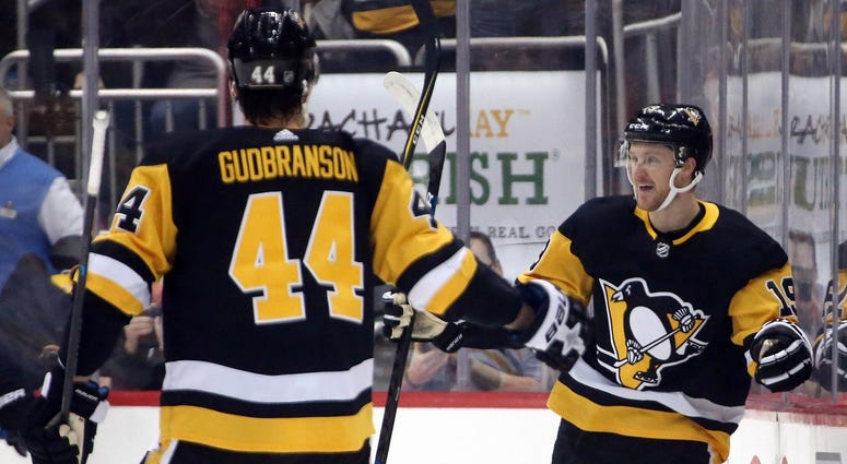 Pittsburgh Penguins center Jared McCann (19) reacts after scoring a goal with Pittsburgh Penguins defenseman Erik Gudbranson (44) against the Boston Bruins during the first period at PPG PAINTS Arena.