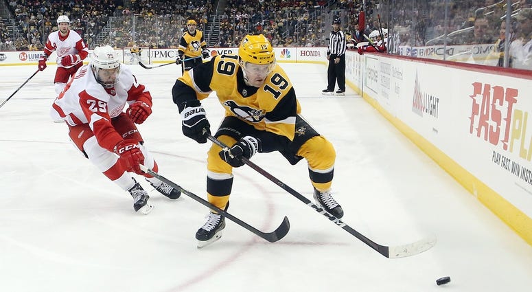 Pittsburgh Penguins center Jared McCann (19) moves the puck ahead of Detroit Red Wings left wing Brendan Perlini (29) during the third period at PPG PAINTS Arena. The Penguins won 5-1.