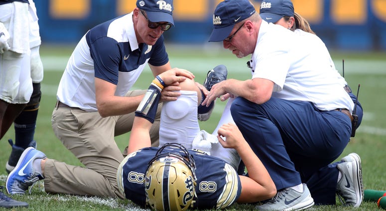 Pittsburgh Panthers trainers look at quarterback Kenny Pickett (8) after a apparent injury against the Georgia Tech Yellow Jackets during the second quarter at Heinz Field.