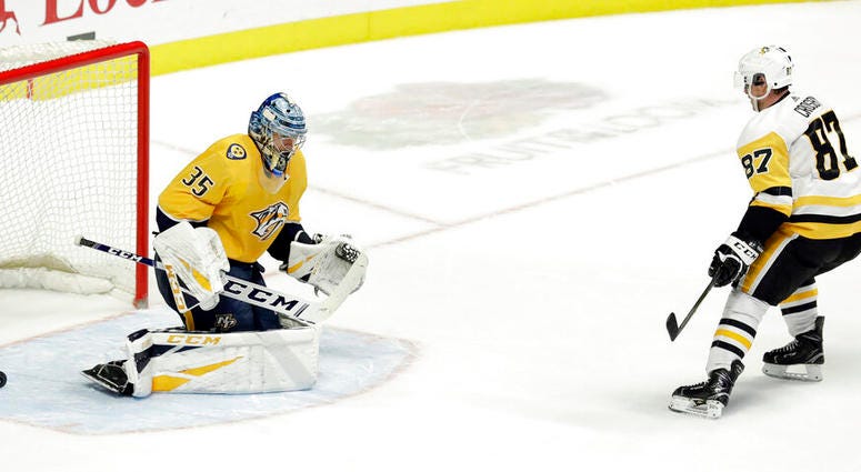 Pittsburgh Penguins center Sidney Crosby (87) scores against Nashville Predators goaltender Pekka Rinne, of Finland, during the shootout in an NHL hockey game Thursday, March 21, 2019, in Nashville, Tenn. The Penguins won 2-1. DO NOT USE