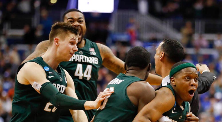 Michigan State guard Cassius Winston, right, celebrates with teammates Matt McQuaid (20), Nick Ward (44) and Gabe Brown (13) after defeating Duke in an NCAA men's East Regional final college basketball game in Washington, Sunday, March 31, 2019. Michigan State guard Cassius Winston, right, celebrates with teammates Matt McQuaid (20), Nick Ward (44) and Gabe Brown (13) after defeating Duke in an NCAA men's East Regional final college basketball game in Washington, Sunday, March 31, 2019.