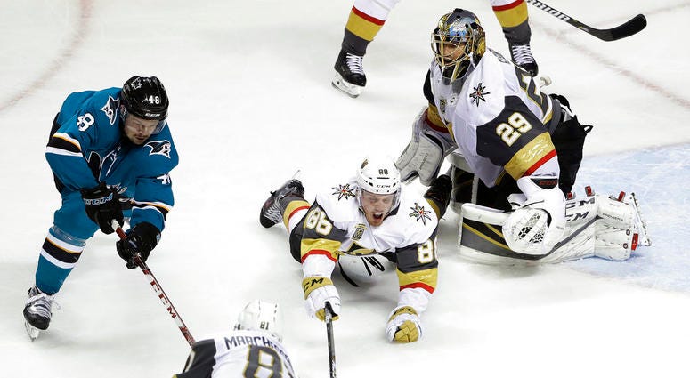 Vegas Golden Knights' Nate Schmidt, center, defends on San Jose Sharks' Tomas Hertl DO NOT USE