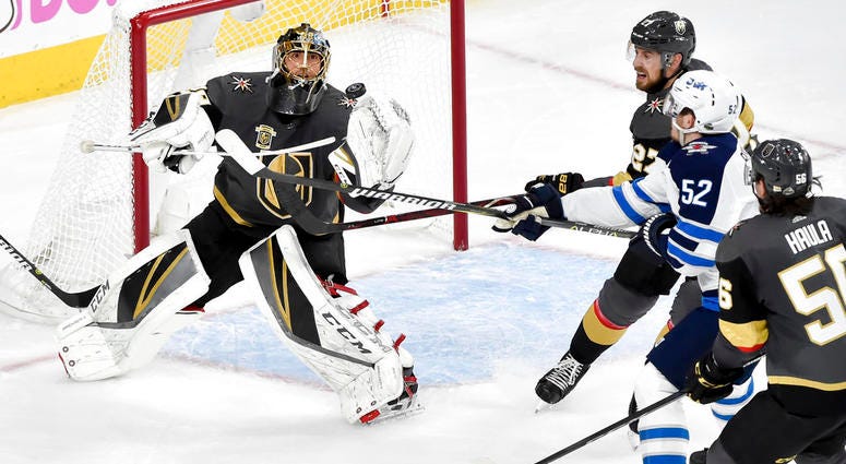Vegas Golden Knights goaltender Marc-Andre Fleury, left, blocks a shot by Winnipeg Jets center Jack Roslovic during the second period DO NOT USE