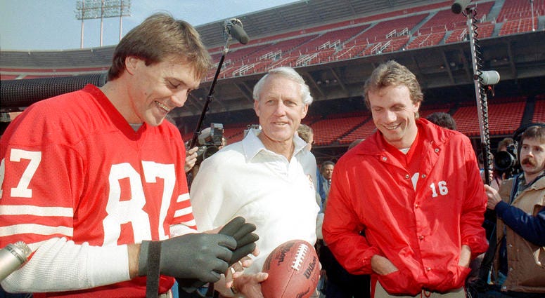 In this Jan. 16, 1985, file photo, San Francisco 49ers' head coach Bill Walsh, center, laughs with quarterback Joe Montana (16) and receiver Dwight Clark, left, at San Francisco's Candlestick Park. DO NOT USE