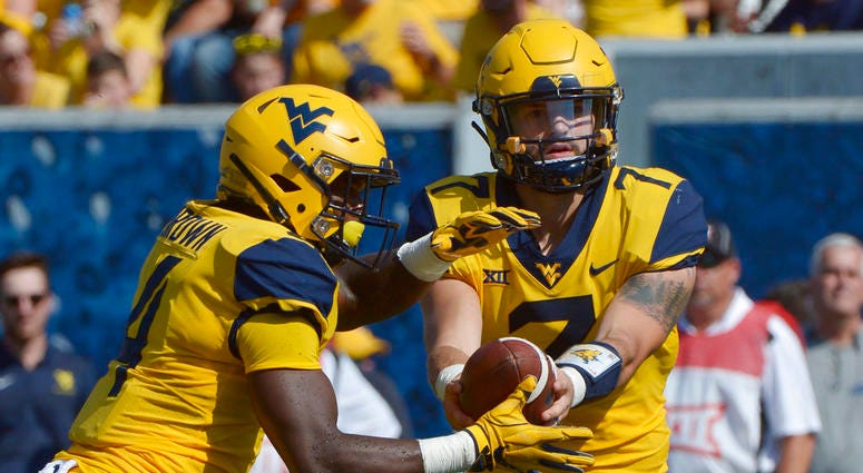 West Virginia quarterback Will Grier (7) hands off the football to running back Leddie Brown (4) during the first half of an NCAA college football game against Kansas in Morgantown, W. Va., Saturday Oct. 6, 2018. DO NOT USE