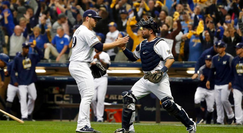 Milwaukee Brewers relief pitcher Corbin Burnes (39) and catcher Manny Pina (9) celebrate after Game 6 of the National League Championship Series baseball game against the Los Angeles Dodgers Friday, Oct. 19, 2018, in Milwaukee. DO NOT USE