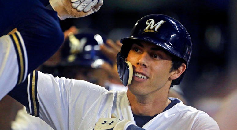 Milwaukee Brewers' Christian Yelich is congratulated by teammates in the dugout Milwaukee Brewers' Christian Yelich is congratulated by teammates in the dugout