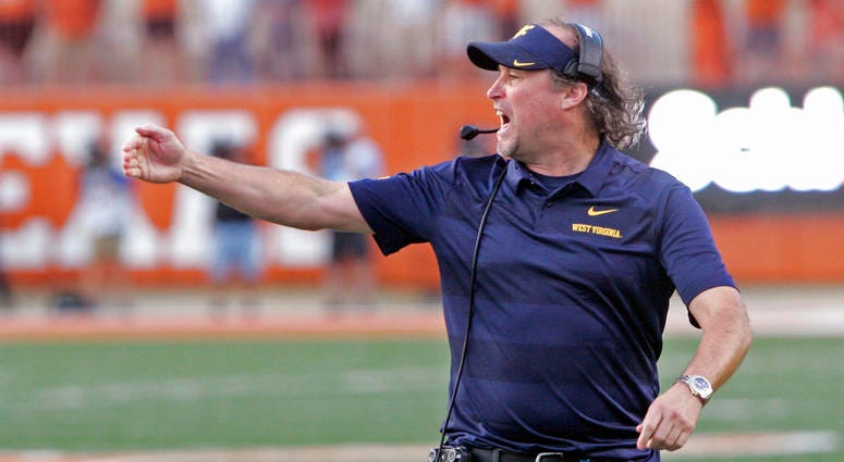 In this Nov. 3, 2018, file photo, West Virginia head coach Dana Holgorsen calls out to his team during the second half of an NCAA college football game against Texas DO NOT USE