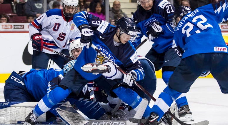Finland goalie Ukko-Pekka Luukkonen, left, stops United States' Noah Cates Finland goalie Ukko-Pekka Luukkonen, left, stops United States' Noah Cates