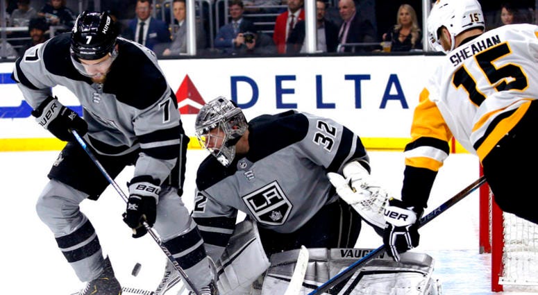 Los Angeles Kings goalie Jonathan Quick, center, protects the next while defenseman Oscar Fantenberg, left, and Pittsburgh Penguins forward Riley Sheahan try to control the puck during the first period of an NHL hockey game Saturday, Jan. 12, 2019. DO NOT USE