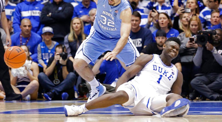 Duke's Zion Williamson (1) falls to the floor with an injury while chasing the ball with North Carolina's Luke Maye (32) during the first half of an NCAA college basketball game in Durham, N.C., Wednesday, Feb. 20, 2019. Duke's Zion Williamson (1) falls to the floor with an injury while chasing the ball with North Carolina's Luke Maye (32) during the first half of an NCAA college basketball game in Durham, N.C., Wednesday, Feb. 20, 2019.