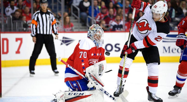 Washington Capitals goaltender Braden Holtby (70) tries to corral the puck, next to New Jersey Devils center Blake Coleman (20) during the first period of an NHL hockey game Friday, March 8, 2019, in Washington AP DO NOT USE