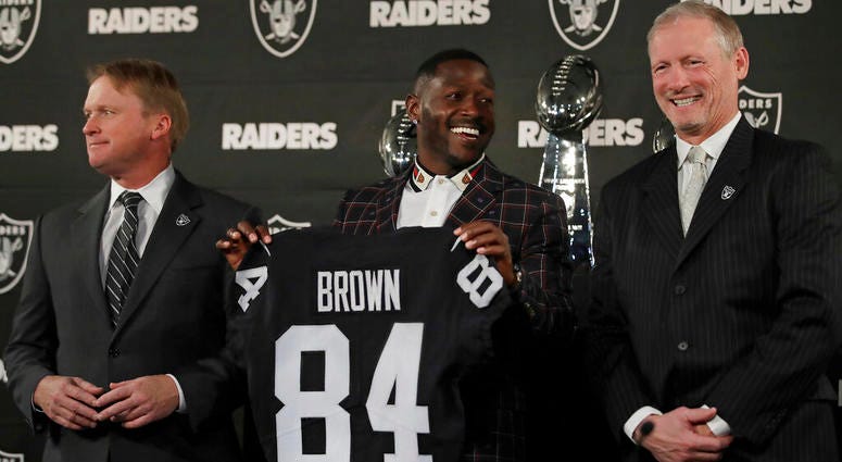 Oakland Raiders wide receiver Antonio Brown, center, holds his jersey beside coach Jon Gruden, left, and general manager Mike Mayock during an NFL football news conference Wednesday, March 13, 2019, in Alameda, Calif. ( Oakland Raiders wide receiver Antonio Brown, center, holds his jersey beside coach Jon Gruden, left, and general manager Mike Mayock during an NFL football news conference Wednesday, March 13, 2019, in Alameda, Calif. (