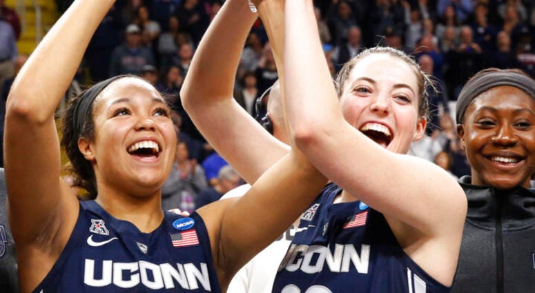 Connecticut forward Napheesa Collier (24) and guard Katie Lou Samuelson (33) hold up the trophy after defeating Louisville in a regional championship final in the NCAA women's college basketball tournament, Sunday, March 31, 2019, in Albany, N.Y. AP DO NOT USE