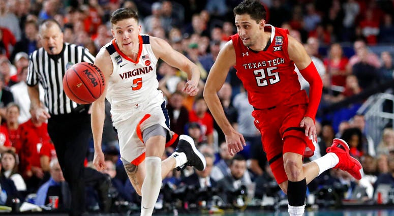 Virginia's Kyle Guy (5) and Texas Tech's Davide Moretti (25) chase a loose ball during the overtime in the championship of the Final Four NCAA college basketball tournament, Monday, April 8, 2019, in Minneapolis. AP DO NOT USE