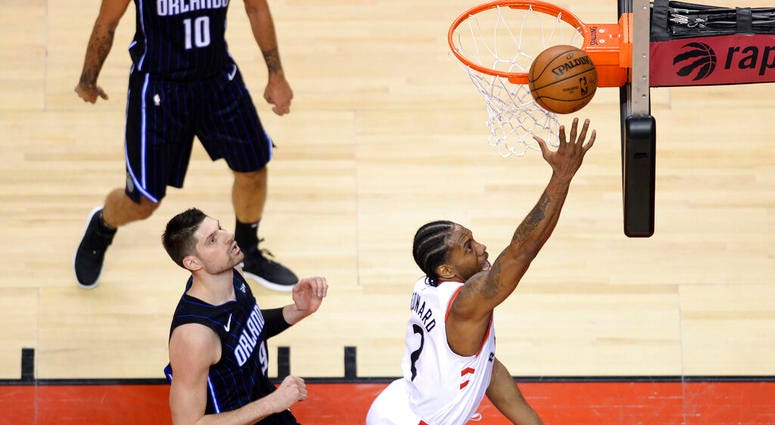 oronto Raptors forward Kawhi Leonard (2) scores on a layup past Orlando Magic center Nikola Vucevic (9) during the second half of Game 2 of an NBA basketball first-round playoff series Tuesday, April 16, 2019, in Toronto. AP DO NOT USE