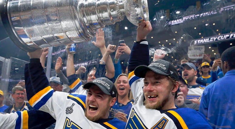 St. Louis Blues' Ivan Barbashev, left, and Vladimir Tarasenko, both of Russia, hold the Stanley Cup as fans in the stands celebrate after the Blues defeated the Boston Bruins in Game 7 of the NHL Stanley Cup Final, Wednesday, June 12, 2019, in Boston. AP DO NOT USE