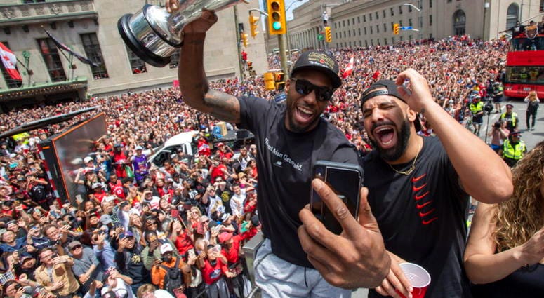 Toronto Raptors' Kawhi Leonard holds his MVP trophy while celebrating with rapper/producer Drake during the team's NBA basketball championship parade in Toronto, Monday, June 17, 2019. AP DO NO TUSE