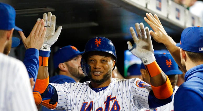 Teammates in the dugout congratulate New York Mets' Robinson Cano after the third of Cano's three home runs AP DO NOT USE