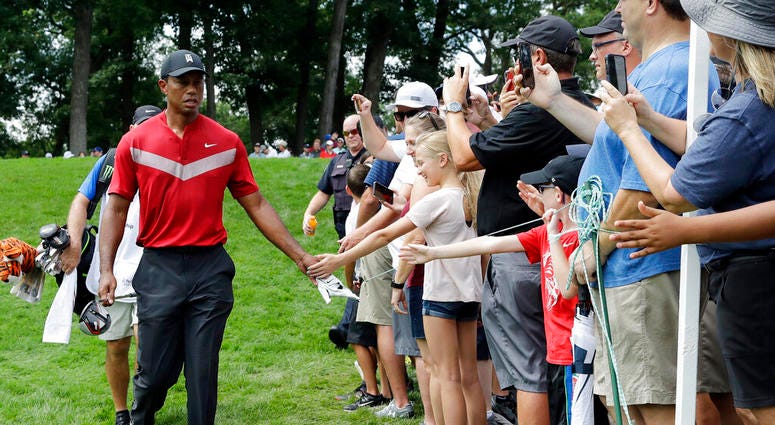 Tiger Woods, left, greets fans as he walks to the 14th fairway after hitting his tee shot during the final round of the BMW Championship golf tournament at Medinah Country Club, Sunday, Aug. 18, 2019, in Medinah, Ill. Tiger Woods, left, greets fans as he walks to the 14th fairway after hitting his tee shot during the final round of the BMW Championship golf tournament at Medinah Country Club, Sunday, Aug. 18, 2019, in Medinah, Ill.