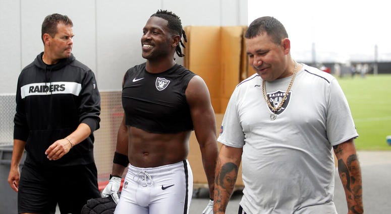 Oakland Raiders' Antonio Brown, center, walks off the field after NFL football practice in Alameda, Calif., Tuesday, Aug. 20, 2019.