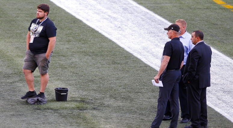 Officials assess the location where the CFL goal post holes were Officials assess the location where the CFL goal post holes were