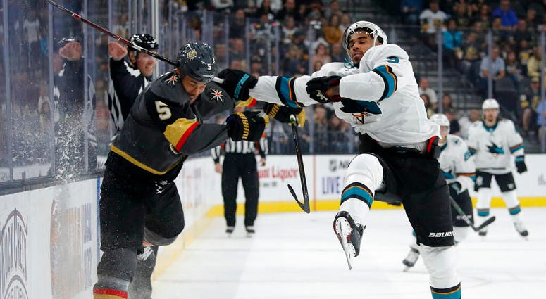 Vegas Golden Knights defenseman Deryk Engelland, left, checks San Jose Sharks left wing Evander Kane during the first period of an NHL preseason hockey game Sunday, Sept. 29, 2019, in Las Vegas.