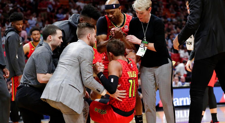 Atlanta Hawks guard Trae Young (11) is helped up off the court after an injury during the first half of the team's NBA basketball game against the Miami Heat, Tuesday, Oct. 29, 2019, in Miami. AP DO NOT USE