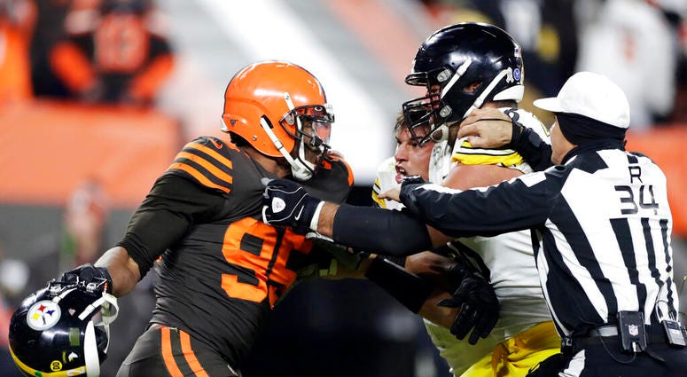 Cleveland Browns defensive end Myles Garrett, left, gets ready to hit Pittsburgh Steelers quarterback Mason Rudolph, second from left, with a helmet during the second half of an NFL football game, Thursday, Nov. 14, 2019, in Cleveland.