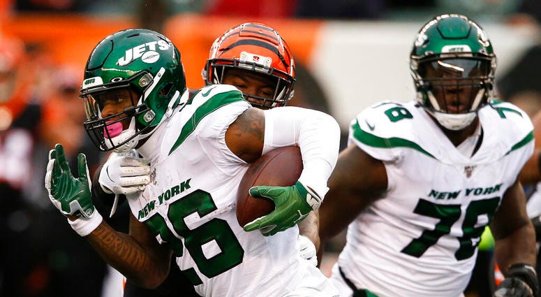 New York Jets running back Le'Veon Bell (26) runs the ball against Cincinnati Bengals linebacker Germaine Pratt, center, during the first half of an NFL football game, Sunday, Dec. 1, 2019, in Cincinnati.