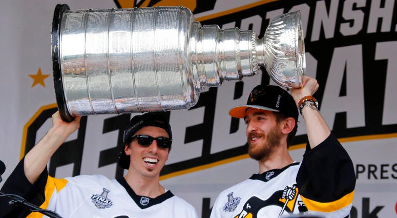 Pittsburgh Penguins goalies Marc-Andre Fleury, left, and Matt Murray hold the Stanley Cup on stage after riding in the Stanley Cup victory parade in Pittsburgh. Pittsburgh Penguins goalies Marc-Andre Fleury, left, and Matt Murray hold the Stanley Cup on stage after riding in the Stanley Cup victory parade in Pittsburgh.